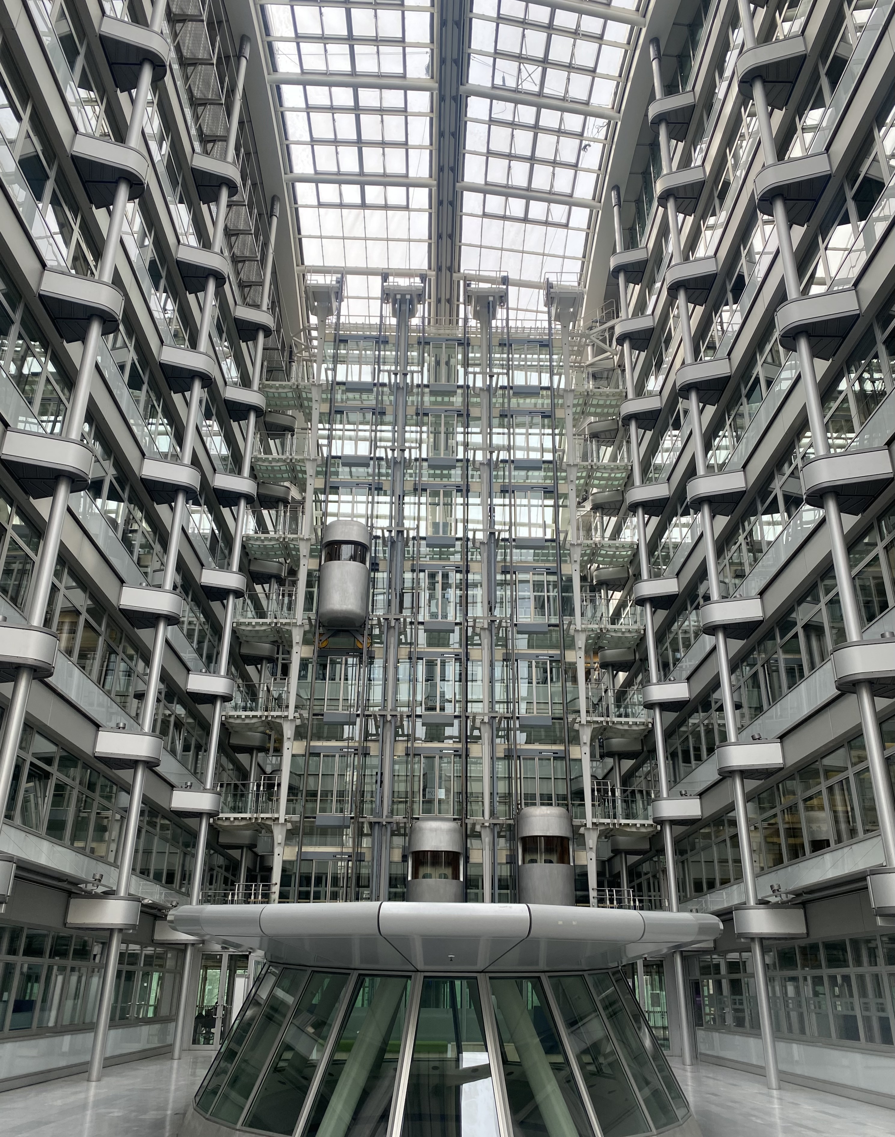 Atrium of the Ludwig Erhard Haus in Charlottenburg, with panoramic lifts rising through a steel-and-glass interior void